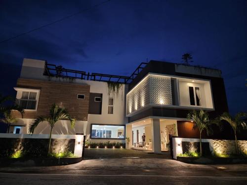 a house with a lit up facade at night at PURNAMA BALIGE HOTEL in Balige
