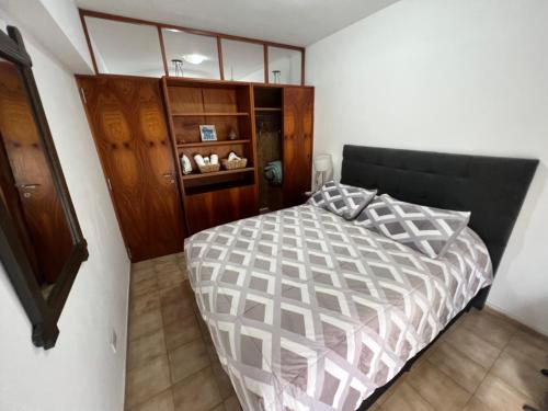 1 dormitorio con 1 cama y armario de madera en Monoambiente en Córdoba