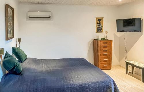ein Schlafzimmer mit einem blauen Bett und einer Kommode in der Unterkunft Beautiful Home In Asarum With Kitchen in Asarum