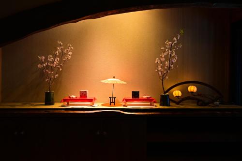 a stage with a table with two chairs and an umbrella at Akari no Yado Okabe in Shibukawa