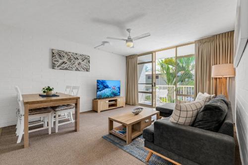 a living room with a couch and a table at Surf Dance Apartments in Coolum Beach