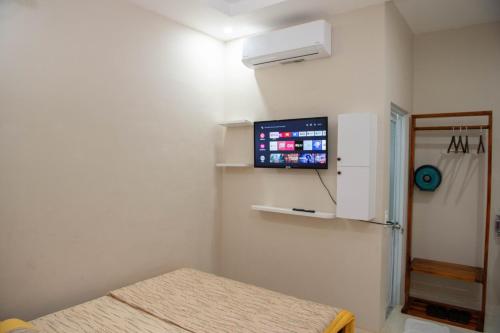 Habitación con cama y TV en la pared. en Nhà khách 369, en Cà Mau