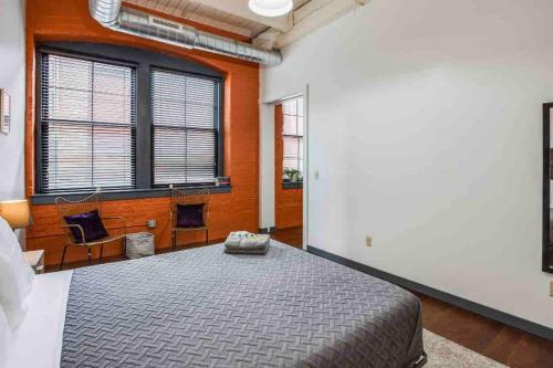 a bedroom with a large bed and a fireplace at Modern Loft Style on Monroe by Dwtn & Park ave in Rochester
