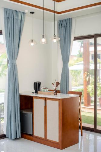 a kitchen with blue curtains and a island in a room at Amphitrite Resort in Panglao