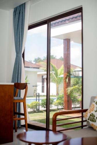 a room with a large window with a table and a chair at Amphitrite Resort in Panglao