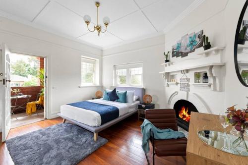 Art Deco Hideaway - St Kilda في ملبورن: غرفة نوم بسرير ومدفأة