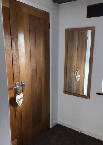 a bathroom with a wooden door and a mirror at Hay On Wye Welsh Townhouse in Hay centre in Hay-on-Wye