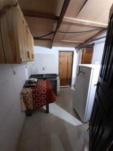 a kitchen with a table and a stove and a refrigerator at HERMOSO APARTAMENTO MONOAMBIENTE ZONA SHOPPING in Colonia Mariano Roque Alonso
