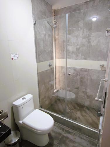 a bathroom with a toilet and a glass shower at Hotel Tierra del Sol Moquegua in Moquegua