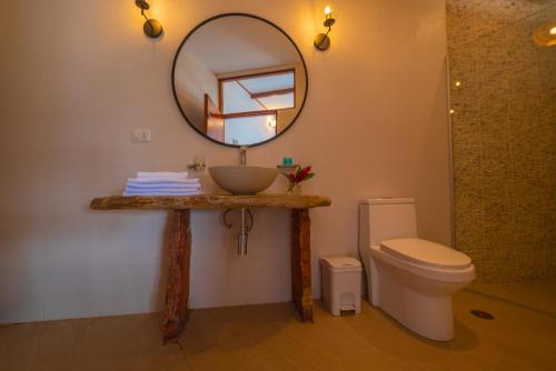 a bathroom with a sink and a mirror and a toilet at Riosol Hotel Laguna Azul in Sauce