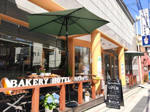a restaurant with a green umbrella in front of it at Bakery Hotel Chateau D'or in Nara