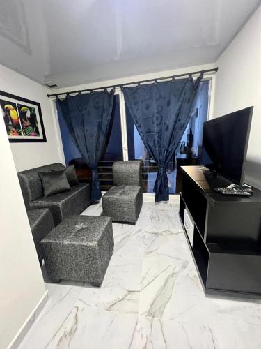 ein Wohnzimmer mit einem Sofa und einem TV in der Unterkunft Comodo Apartamento Cartago Valle in Cartago