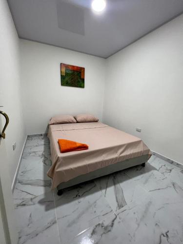 Schlafzimmer mit einem Bett mit Wandgemälde in der Unterkunft Comodo Apartamento Cartago Valle in Cartago