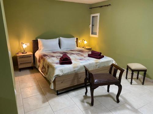 a bedroom with a bed and a chair and a table at CASA JOHN in Alepou