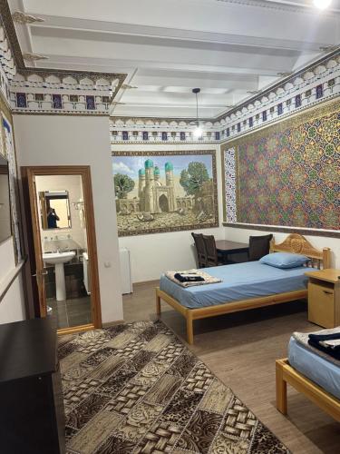 a bedroom with two beds and a painting on the wall at TEMUR Hotel in Bukhara