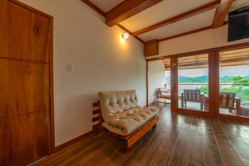 a living room with a chair and a balcony at Riosol Hotel Laguna Azul in Sauce