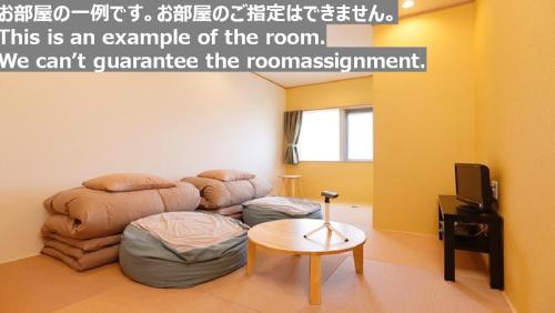 Habitación con sofá y mesa. en Tabist Onsen Petit Hotel Yukori Bandai Atami en Koriyama