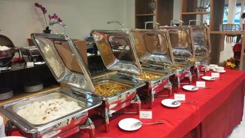 a row of trays of food sitting on a table at OPI Indah Hotel in Palembang