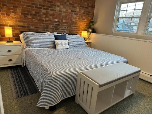 a bedroom with a bed and a brick wall at Ocean Breeze-8min Walk to Beach in Gloucester