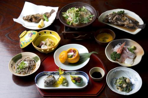 a wooden table with plates of food on it at Jinpuso in Miyazu