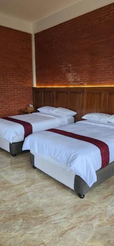 a group of three beds in a room at The Mungseng Villa Bali in Singaraja