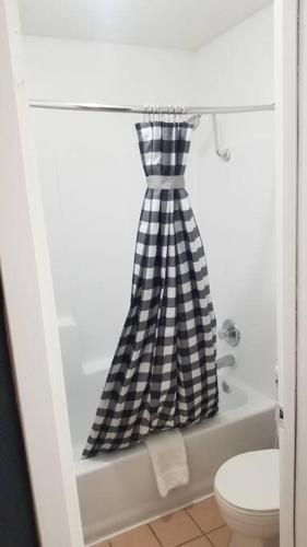 a black and white checkered shower curtain in a bathroom at Hotel King Hotel Room 108 Booking in Stillwater