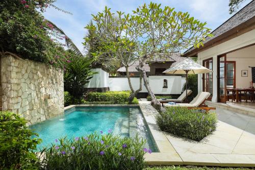 a swimming pool in the backyard of a house at Jimbaran Beach Villas by Nakula in Jimbaran