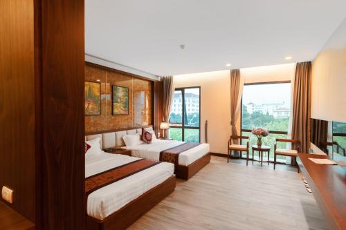 a hotel room with two beds and a window at MT Collection Hotel in Ninh Binh