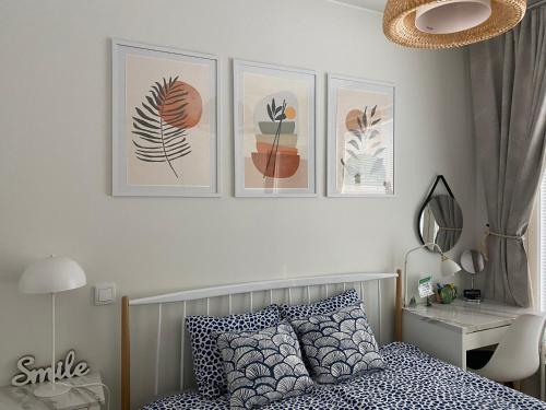 a bedroom with a bed and three pictures on the wall at QnQ home in Helsinki