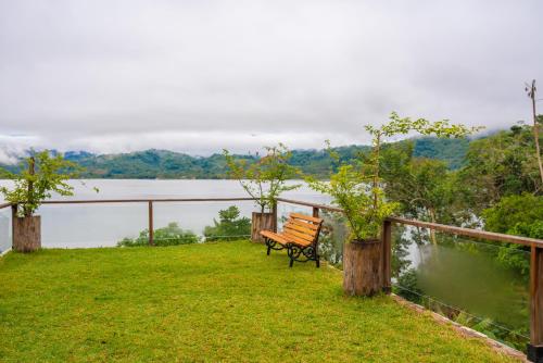 a bench sitting on top of a hill overlooking a lake at Riosol Hotel Laguna Azul in Sauce