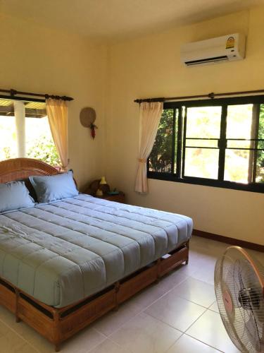 a bedroom with a large bed in a room with windows at Samui Garden Resort in Bang Rak Beach