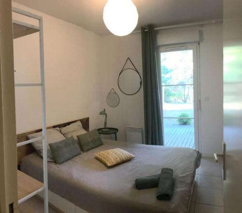 1 dormitorio con cama y ventana grande en Maison à 300m de la plage en Moliets-et-Maa