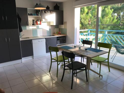 cocina con mesa y sillas y patio en Maison à 300m de la plage en Moliets-et-Maa