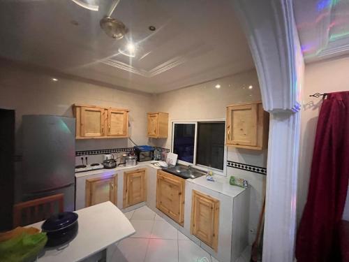 uma cozinha com armários de madeira e um frigorífico branco em B&Y Holiday Apartments em Brusubi