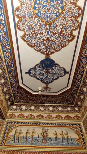 an ornate ceiling in a building with blue and gold at Hotel Shekhawati Haveli in Mandāwa