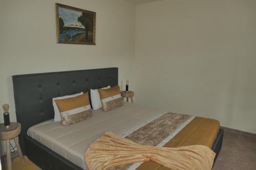 Sabóia的住宿－Casa Alegria，一间卧室配有一张大床和大床头板