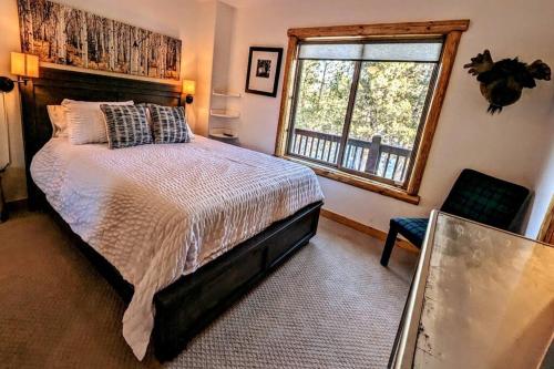 a bedroom with a large bed and a window at Bel Air of Big Bear - Fun & Tech & Massive Cabin in Big Bear City