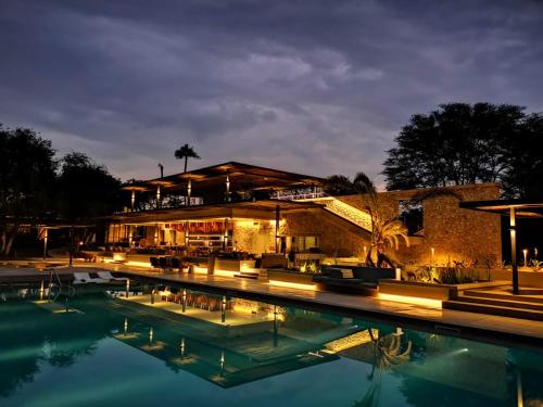 un complejo con piscina por la noche en Mokuti Etosha, en Namutoni