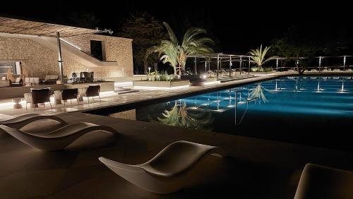 a swimming pool at night with chairs and a table at Mokuti Etosha in Namutoni