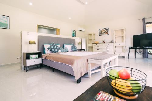 a bedroom with a bed and a table with a bowl of fruit at Denika's Suites in Puerto Princesa City
