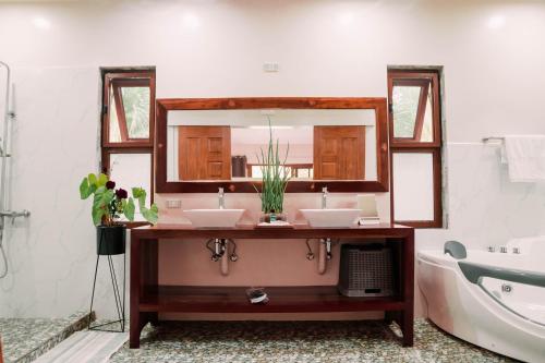 a bathroom with two sinks and a mirror at Denika's Suites in Puerto Princesa City