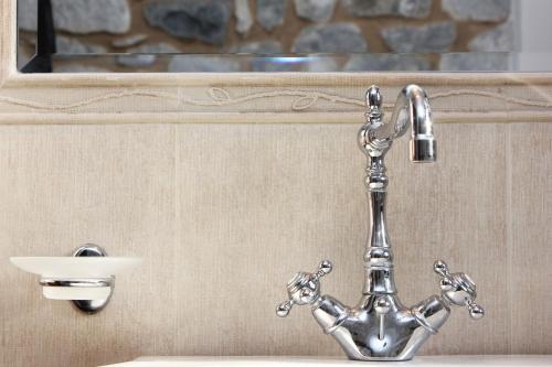 a metal faucet and a sink in a bathroom at Abelos Villas in Áyios Ioánnis
