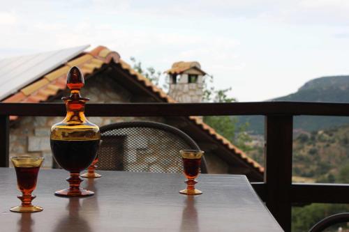 a table with two glasses of wine on a balcony at Abelos Villas in Áyios Ioánnis