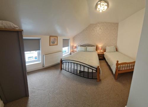 - une chambre avec 2 lits et 2 fenêtres dans l'établissement Ulverston Town Centre Flat (2 Bedrooms), à Ulverston
