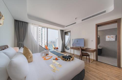 a hotel room with a large white bed with a desk at Grand Tourane Nha Trang Hotel in Nha Trang
