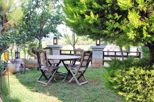 a wooden table and chairs in a yard at Abelos Villas in Áyios Ioánnis
