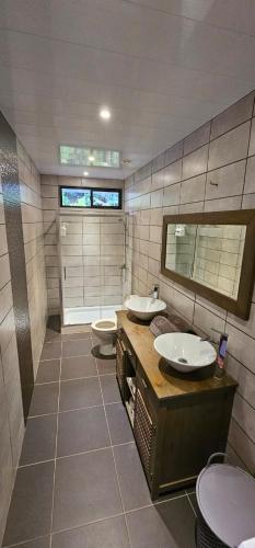 a bathroom with two sinks and a toilet at Spacieux et charmant Appartement Heremata - Arue - Tahiti in Arue
