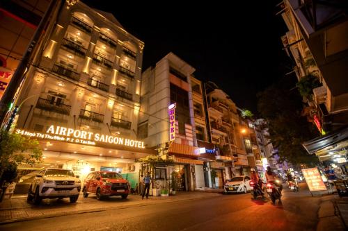 a city street at night with cars parked in front of buildings at Airport Saigon Hotel - Gần ẩm thực đêm chợ Phạm Văn Hai in Ho Chi Minh City