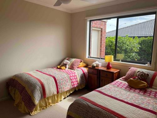 - une chambre avec 2 lits et une fenêtre dans l'établissement Mid Coast Stayz, à Waurn Ponds
