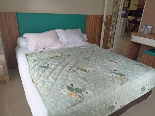a bed with a quilt on it in a bedroom at SpringHills Villa Panderman Batu - Private Pool in Tlekung